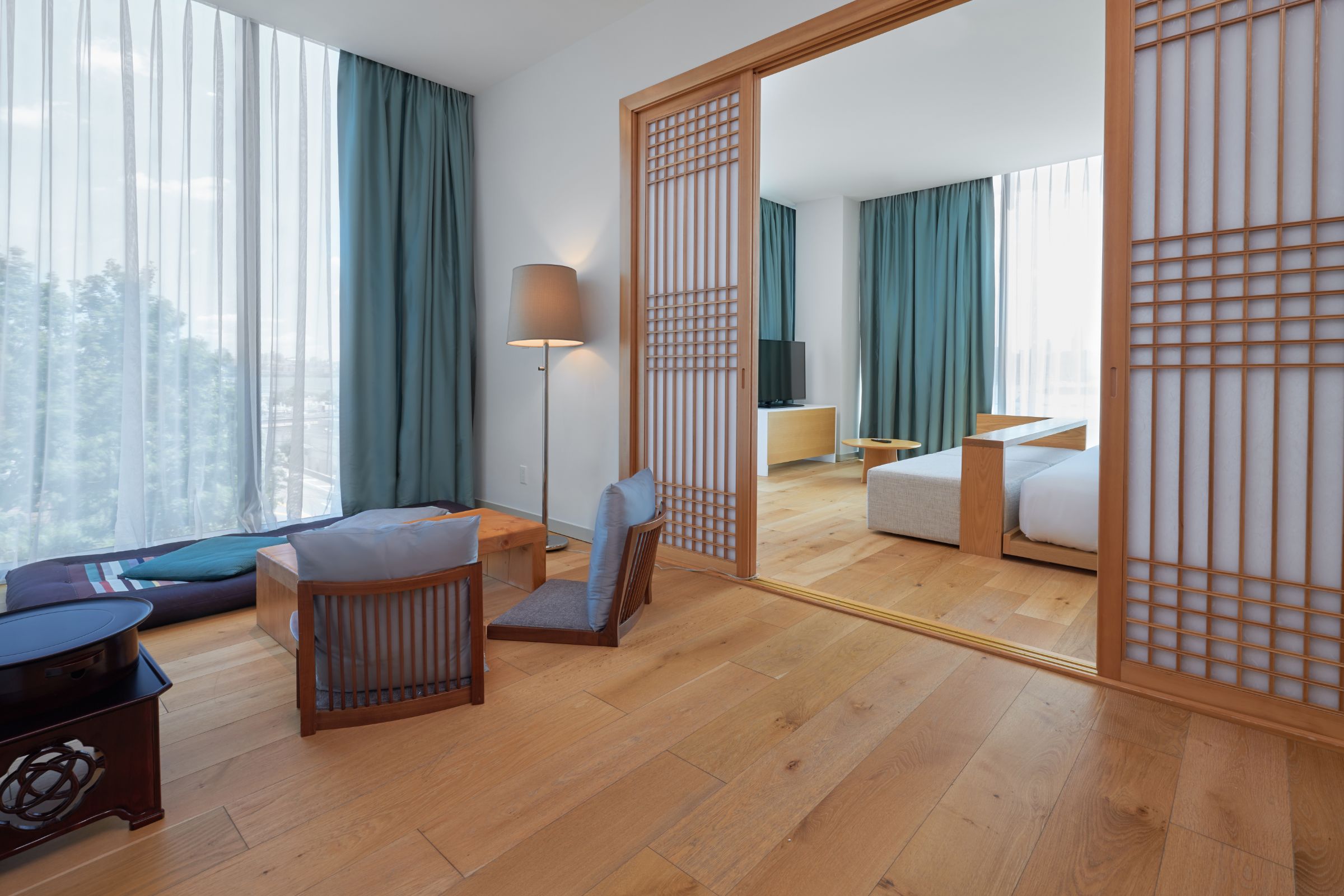 Corner Suite at Hotel SoJo designed with Eastern Asian aesthetic, sitting tea room, bright lights and wood floors.