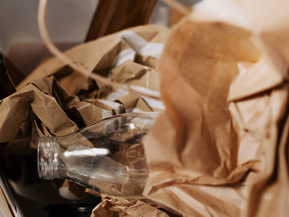 Clear bottle among crumpled brown paper