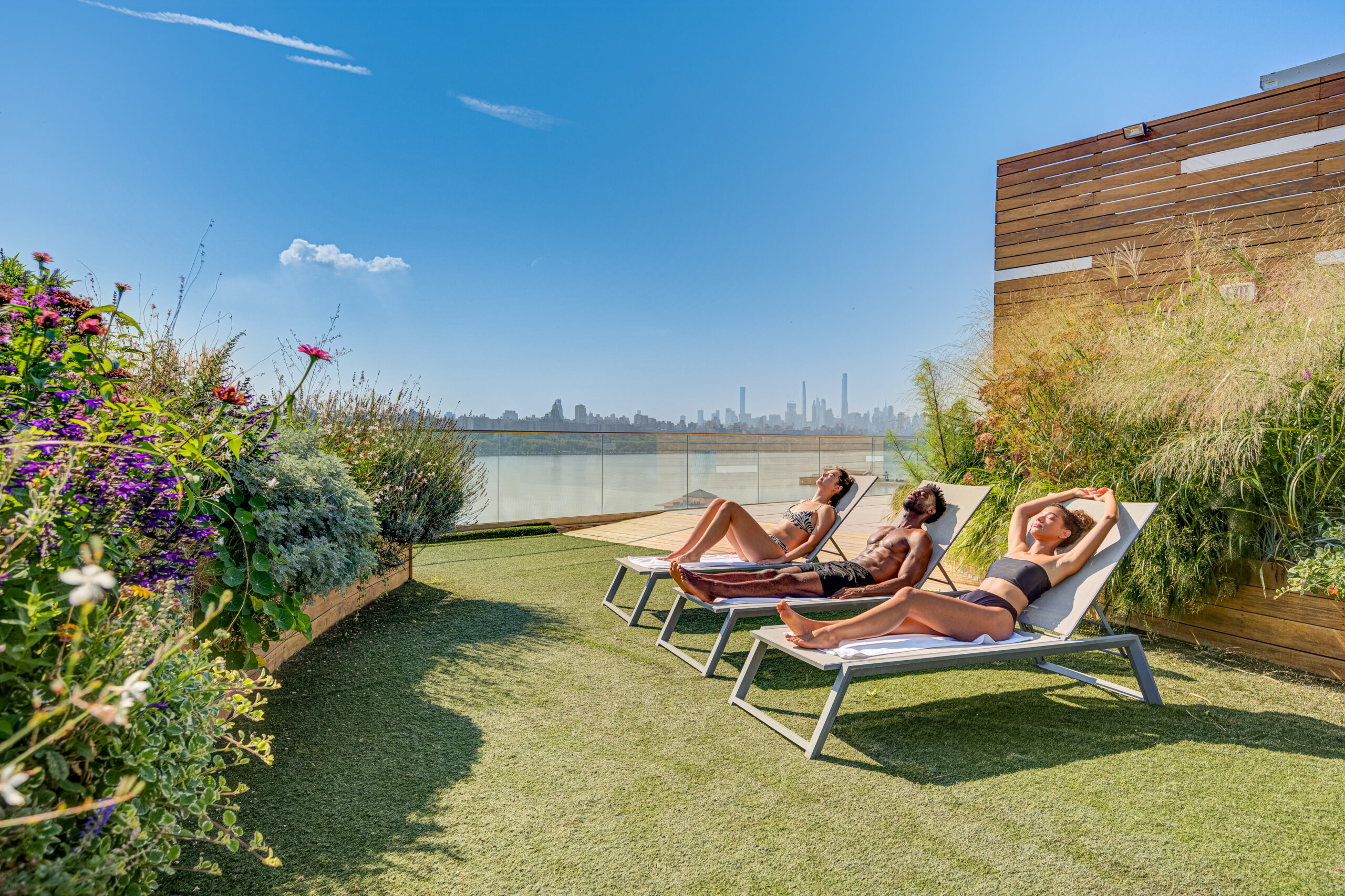 Two women and man sunbathing on rooftop garden at SoJo Spa Club