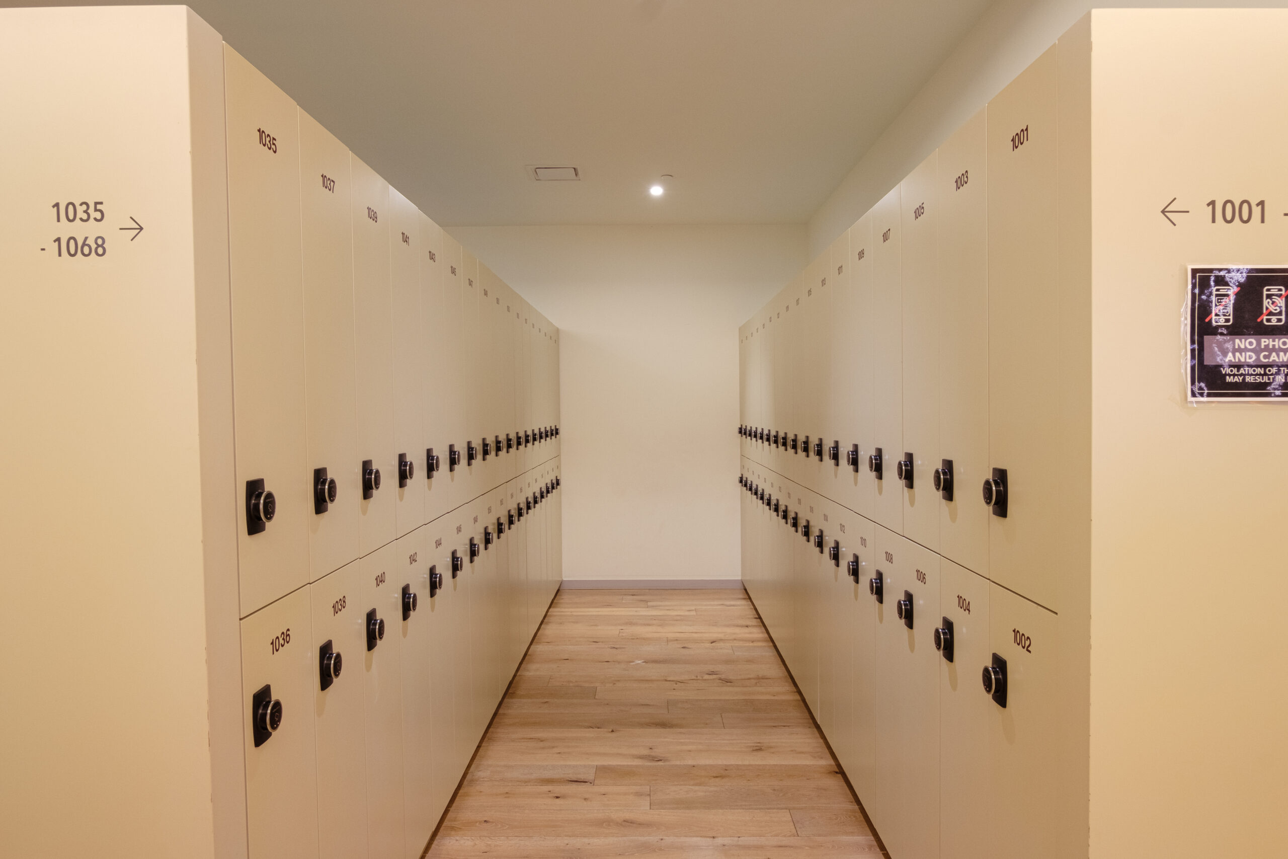 Looking down an aisle of lockers in a locker room.